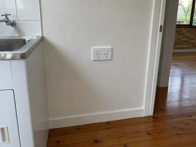 White double power point on a painted kitchen wall beside a sink and timber floor in Ettalong Beach