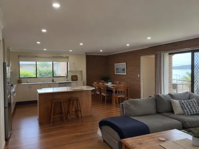 Open-plan living and kitchen with recessed LED downlights in a cream ceiling in Booker Bay